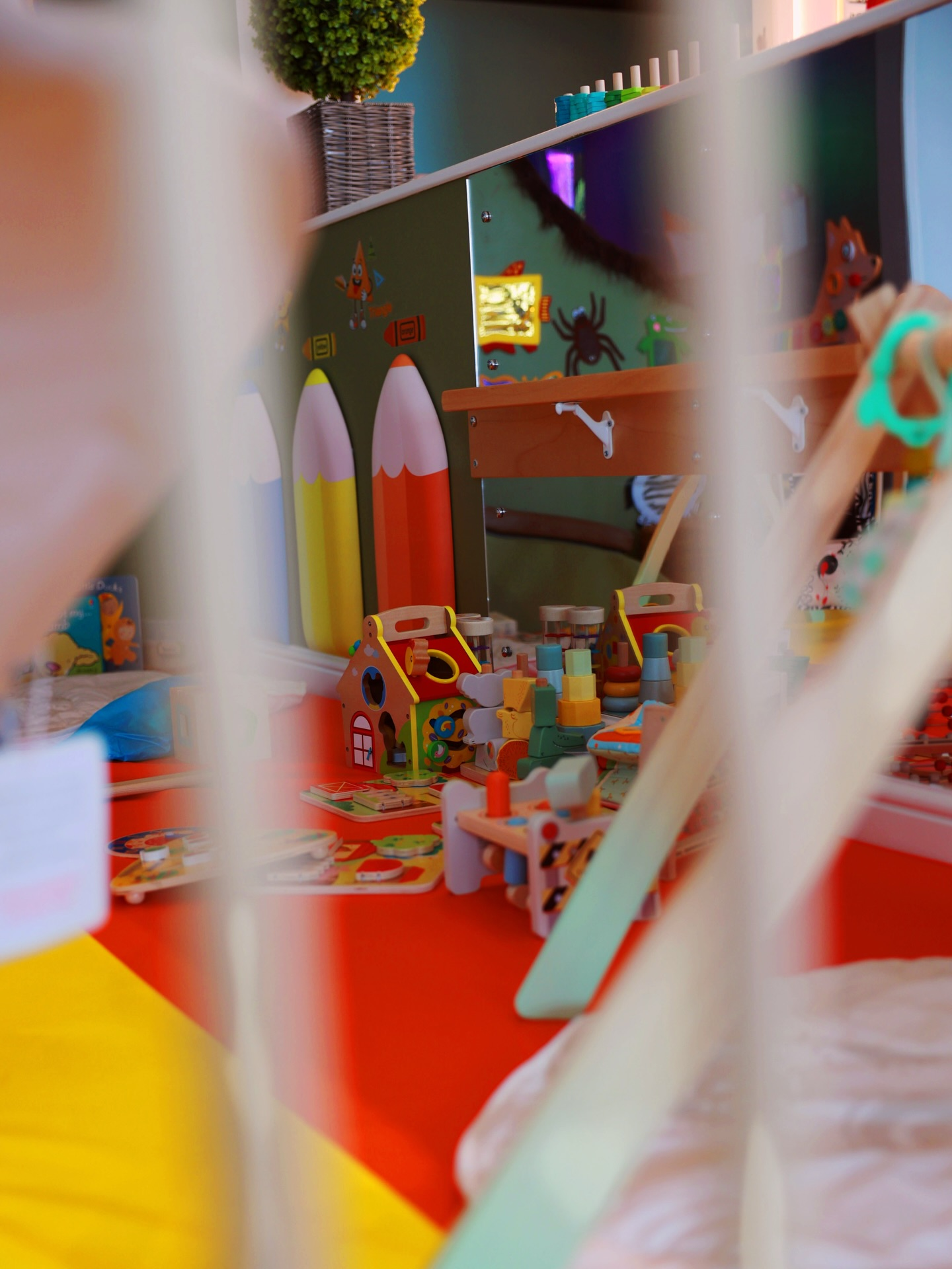 Toddler safe zone with wooden toys and soft play area